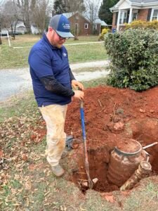 plumber fixing a pipe outdoors