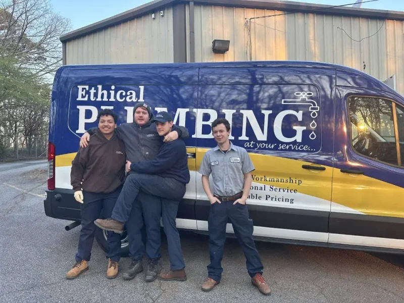 Ethical Plumbing crew beside a company box truck