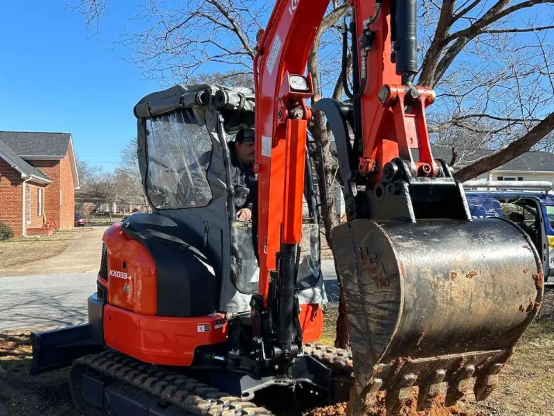 Mini excavator digging for a sewer line replacement