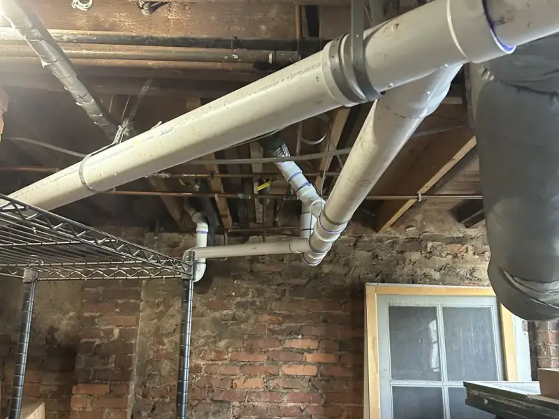 New PVC sewer piping in a basement ceiling