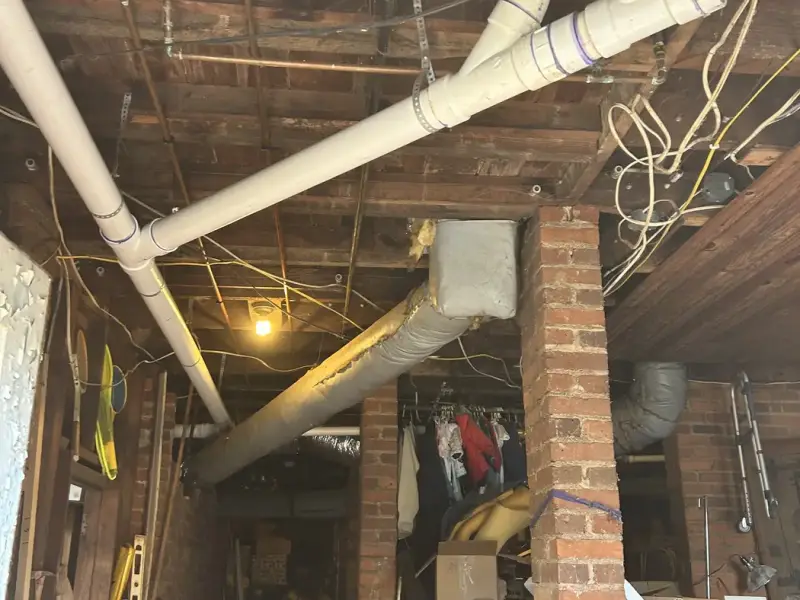New PVC drain and sewer piping run through a basement
