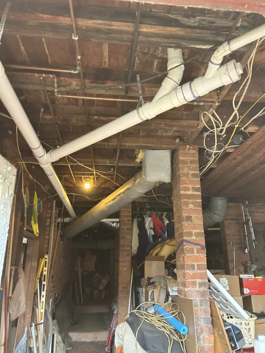 New PVC drain and sewer piping run through a basement