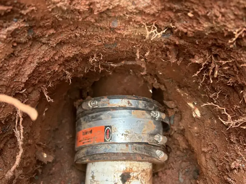 Coupling joining new PVC to the existing sewer line in the dig