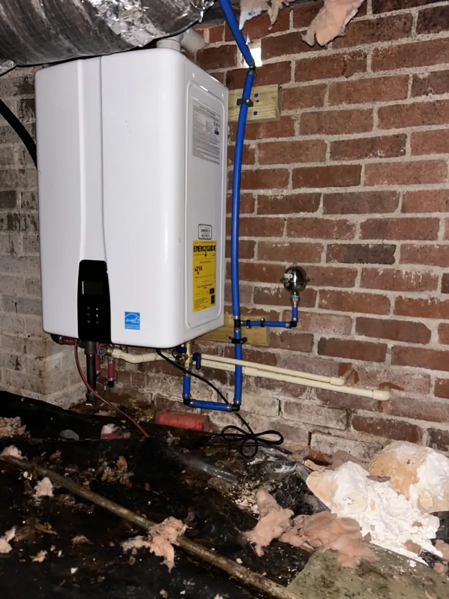 New Navien tankless water heater mounted on a brick crawl space wall