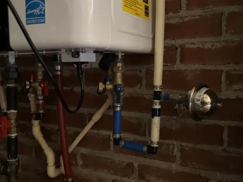 Tankless water heater with isolation valves on a brick wall