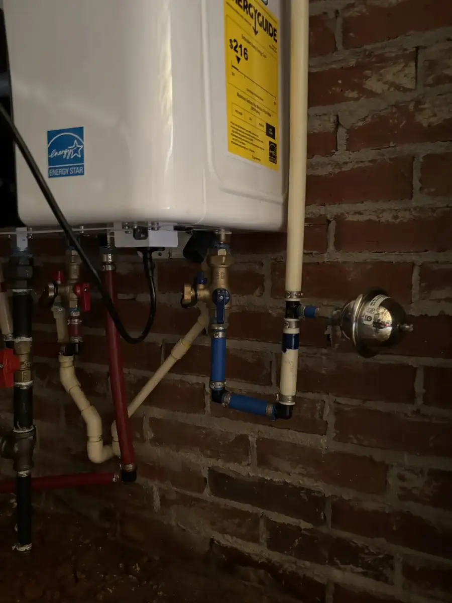 Tankless water heater with isolation valves on a brick wall