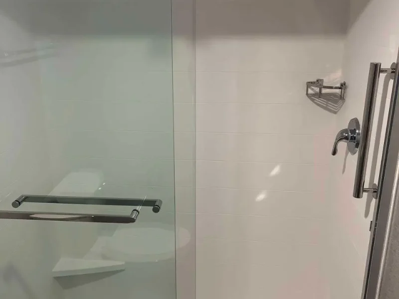 Renovated hotel shower with grab bar and new valve