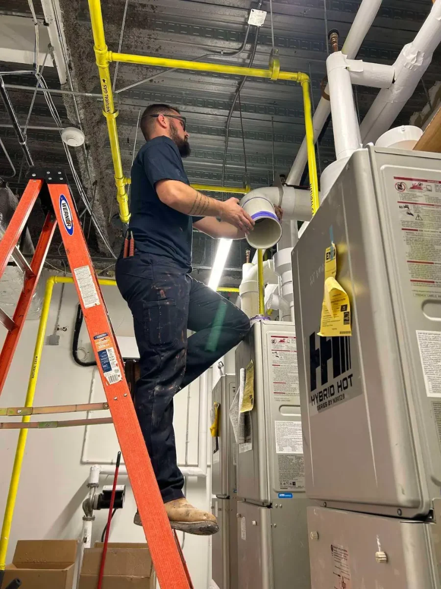 Ethical Plumbing Master Plumber fitting new venting in a commercial mechanical room