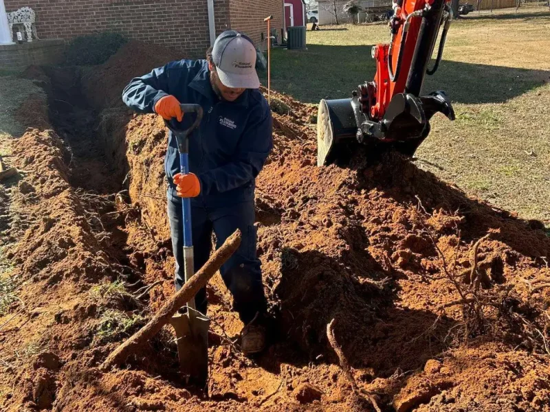 Plumber working in the trench during a sewer line replacement