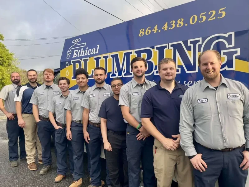 Ethical Plumbing plumbers lined up in front of a company truck