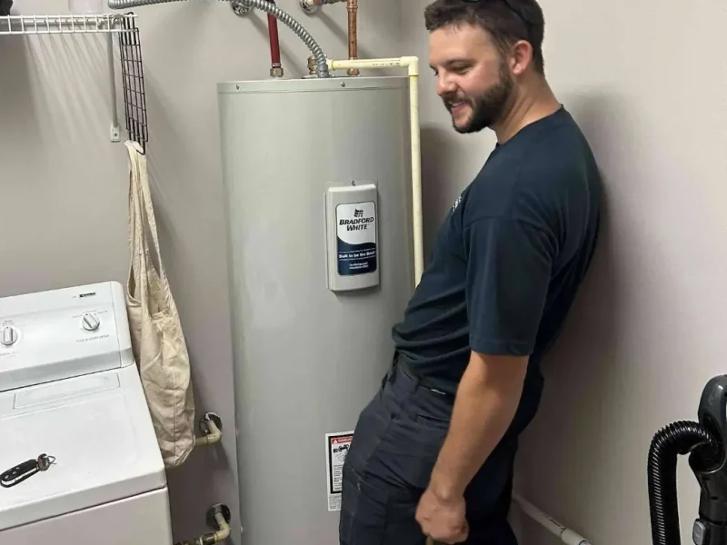 Plumber with an electric water heater in a laundry room